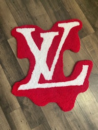 a red and white rug with the louis vu logo on it