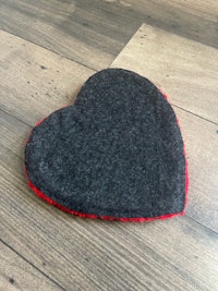 a heart shaped felt pad on a wooden floor