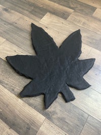 a black leaf sitting on a wooden floor